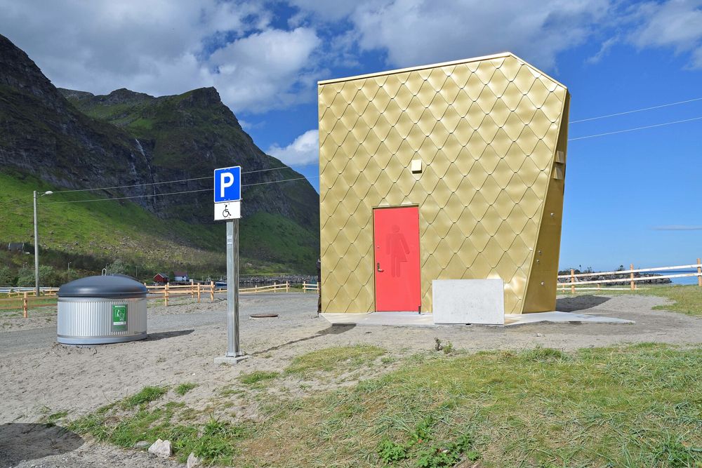The gold-clad toilet at Ersfjordstranda with a red door, under a blue sky